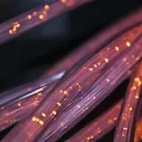 Światłowody FTTH, czyli "Fiber to the Home", to nowoczesna technologia dostarczania internetu. Widać tu ich skupisko, rozświetlone pomarańczowymi iskierkami.