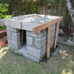 Budowa pieca chlebowego w ogrodzie. Konstrukcja z bloczków betonowych z drewnianym szalunkiem pod strop.