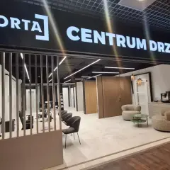 Salon drzwi i okien PORTA z ekspozycją drzwi, meblami i ekspressem do kawy.