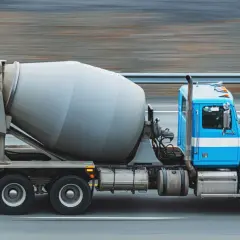 Niebieska gruszka betoniarki pędzi po drodze. Zastanawiasz się, ile kosztuje beton z gruszki?