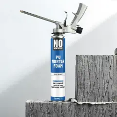 Pistolet do pianki montażowej "No Nonsense" gotowy do pracy, obok betonowych bloków.