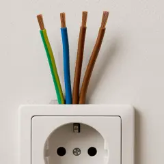 Cztery przewody wychodzące z gniazdka elektrycznego: zielono-żółty, niebieski i dwa brązowe. Jaki kabel do instalacji elektrycznej w domu?