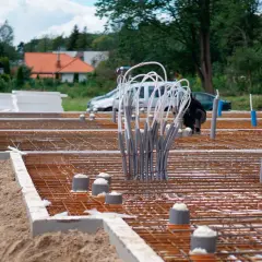 Budowa fundamentu betonowego pod słup. Zbrojenie i rury instalacyjne czekają na zalanie.