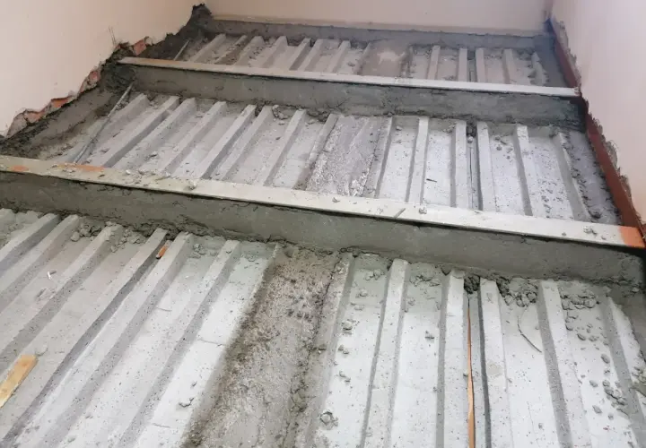Wzmocnienie stropu w starym domu: betonowe belki i stalowe wsporniki tworzą solidną konstrukcję.