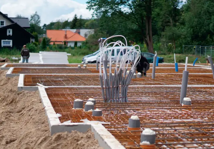 Budowa fundamentu betonowego pod słup. Zbrojenie i rury instalacyjne czekają na zalanie.