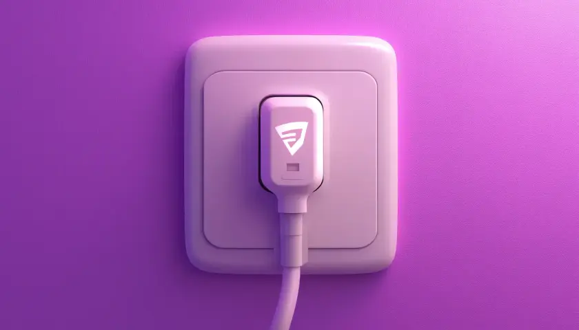 Różowy kabel przyłączeniowy do domu z białym logo wtyczki, podłączony do gniazdka na fioletowej ścianie.