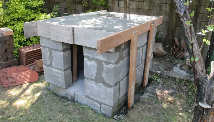 Budowa pieca chlebowego w ogrodzie. Konstrukcja z bloczków betonowych z drewnianym szalunkiem pod strop.