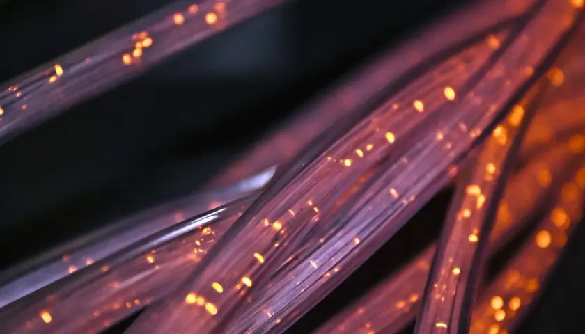 Światłowody FTTH, czyli "Fiber to the Home", to nowoczesna technologia dostarczania internetu. Widać tu ich skupisko, rozświetlone pomarańczowymi iskierkami.