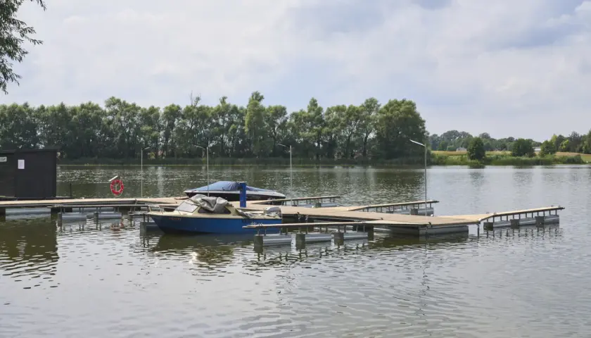 Drewniany pomost na stawie, idealny do cumowania łodzi. Zastanawiasz się, jak zrobić pomost na stawie? Oto przykład.
