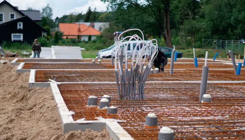 Budowa fundamentu betonowego pod słup. Zbrojenie i rury instalacyjne czekają na zalanie.