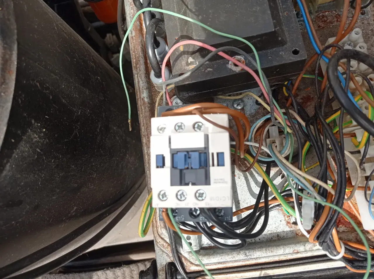 Widok z bliska na wyłącznik silnikowy Schneider z licznymi przewodami w skrzynce elektrycznej.