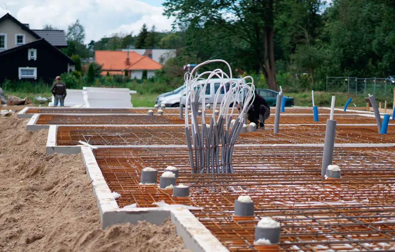 Budowa fundamentu betonowego pod słup. Zbrojenie i rury instalacyjne czekają na zalanie.