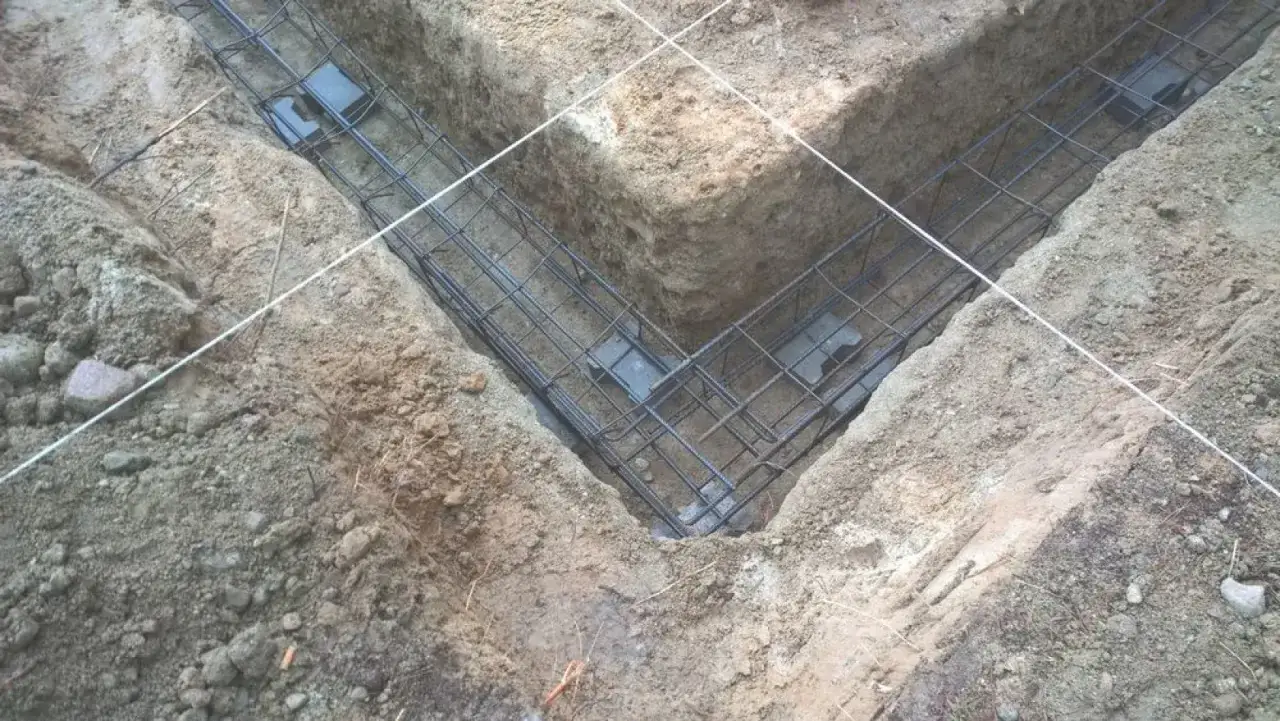 Zbrojenie fundamentowe w wykopie pod budowę. Solidny fundament betonowy pod słup zapewni stabilność konstrukcji.