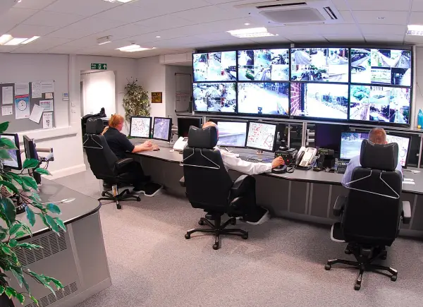 Operatorzy monitorują obraz z kamer CCTV na wielu ekranach. To centrum dowodzenia, gdzie cctv co to jest, jest kluczowe dla bezpieczeństwa.